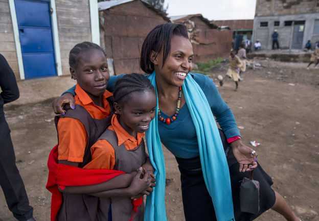 Miss Koch embraces two female students in the Girl Education Project, focused on sexual reproductive health awareness, in Korogocho in Nairobi, Kenya.