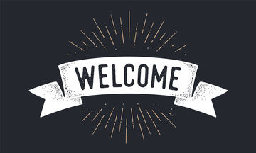The world "welcome" on a chalkboard background